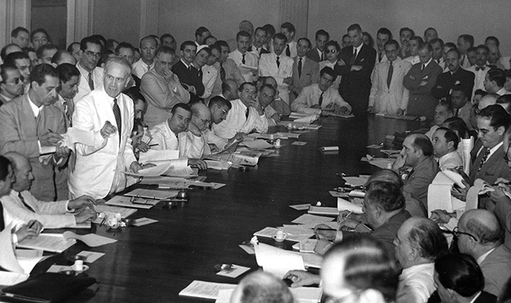  <strong> De terno branco, Osvaldo Aranha se pronuncia </strong> durante reunião de chanceleres americanos no Ministério das Relações Exteriores (Itamaraty)