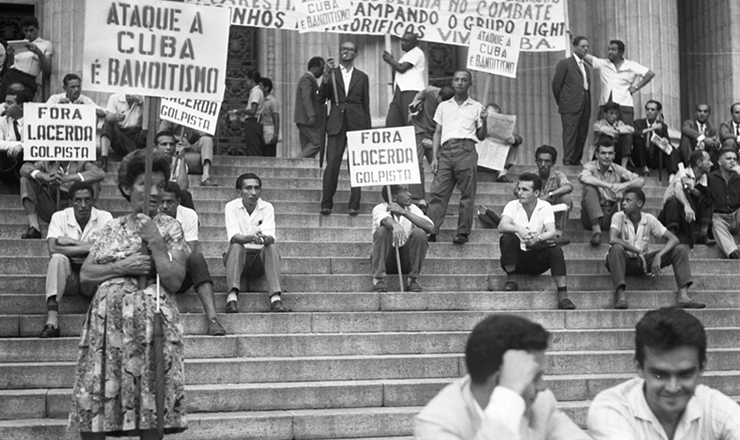 <strong> Manifestantes seguram </strong> faixas e cartazes em frente ao Teatro Municipal do Rio contra a posição do Brasil na Conferência de Punta Del Este, em agosto de 1961   