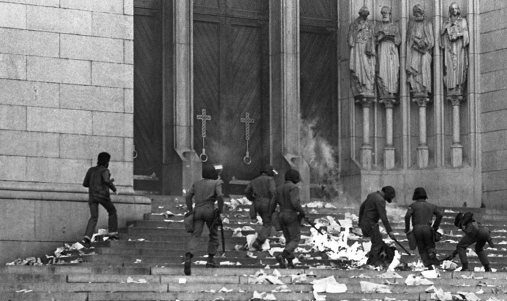 Moradores de rua na escadaria da Catedral da Sé se alimentando com