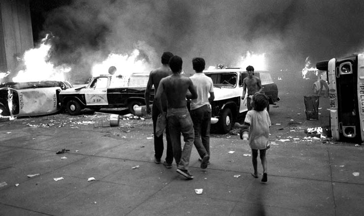  <strong> Viaturas da polícia incendiadas </strong> em protesto em Brasília contra o Plano Cruzado 2; os manifestantes faziam passeata e reagiram à forte repressão policial 
