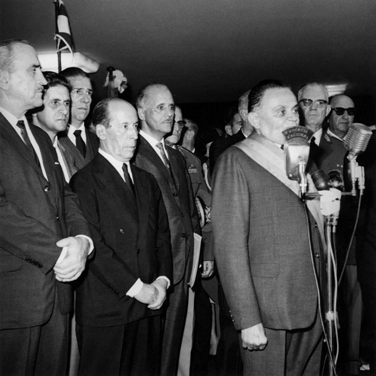  <strong> Castelo Branco discursa </strong> em sua posse, observado pelo futuro general presidente Ernesto Geisel (ao fundo, à dir.)